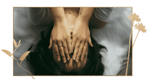 Woman lying down with hands covering face
