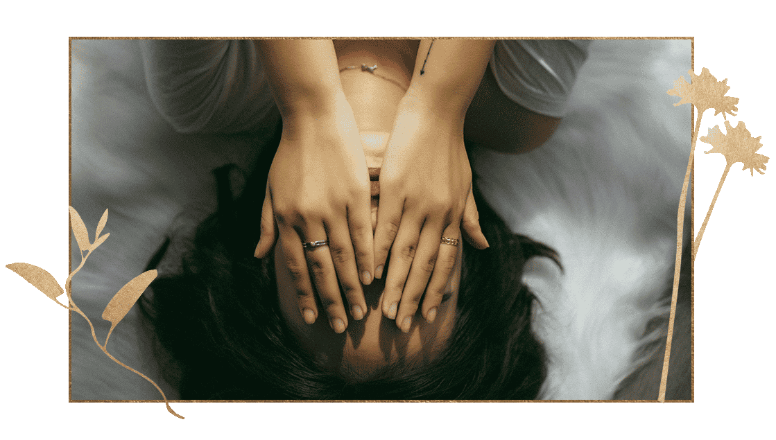 Woman lying down with hands covering face